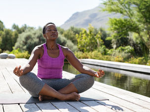 woman sitting on deck in meditation position