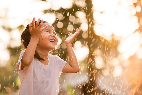 Menina feliz na chuva.
