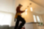 Electrician installing light fixtures in a home