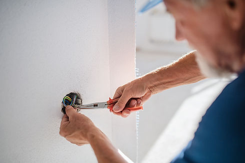 Old man working on interior of new house or flat