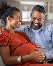 Pregnant couple sitting on a couch
