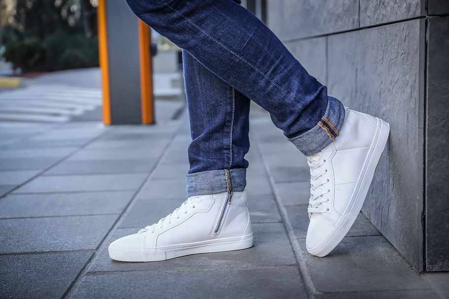 person wearing turned up jeans and white trainers