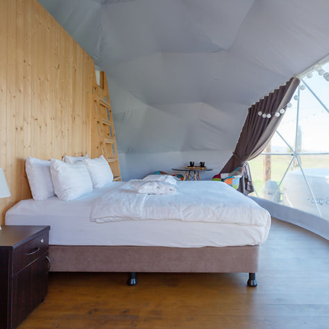 Domo geodésico integrado en un paisaje natural de montaña en Oaxaca, bajo un cielo estrellado y rodeado de vegetación nativa