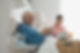 Senior man sitting with home care nurse eating breakfast