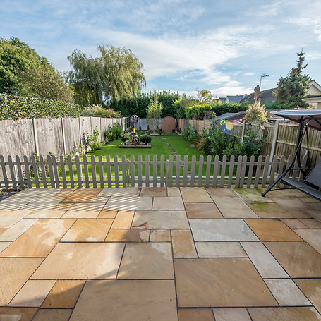 A general view of a sandstone slab paving patio with swing chair