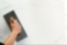close-up image of a person's hand while using plastering trowel