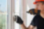 master with a screwdriver sets fittings on the window