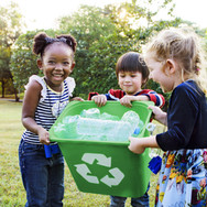 Girls Carrying a Recycling Bin