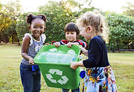 Girls Carrying a Recycling Bin