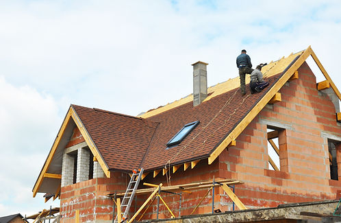Two workers installing shingles on a steep residential roof