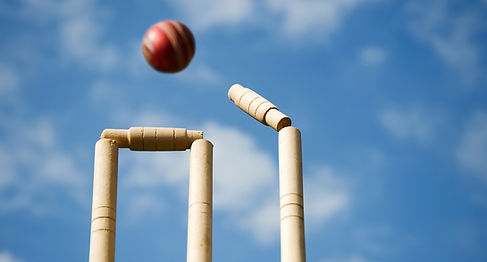 A cricket ball hiting the wickets