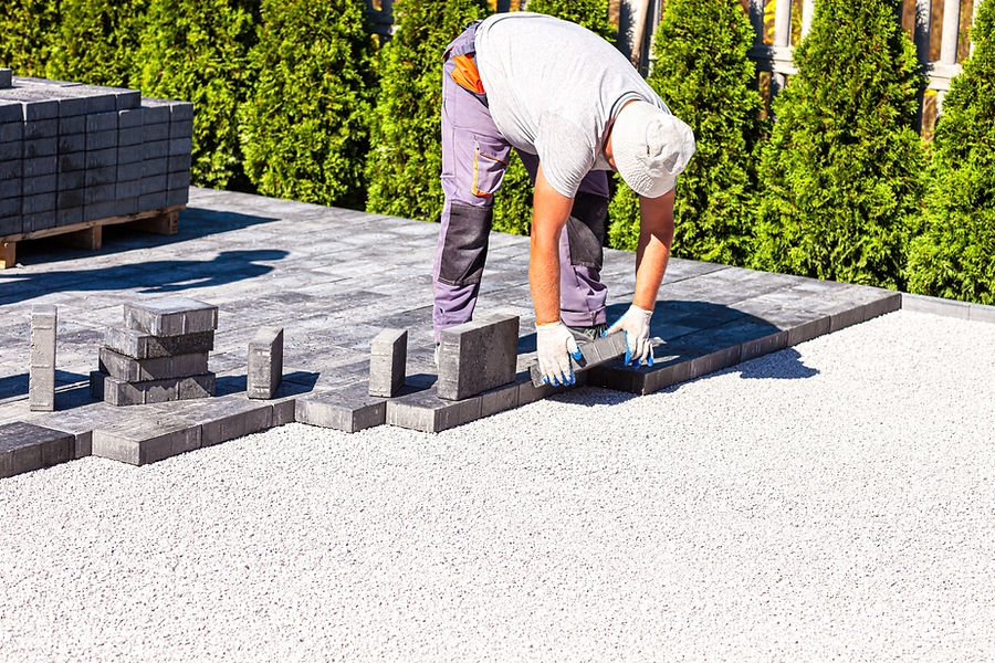 A paver is laying paving stones. 