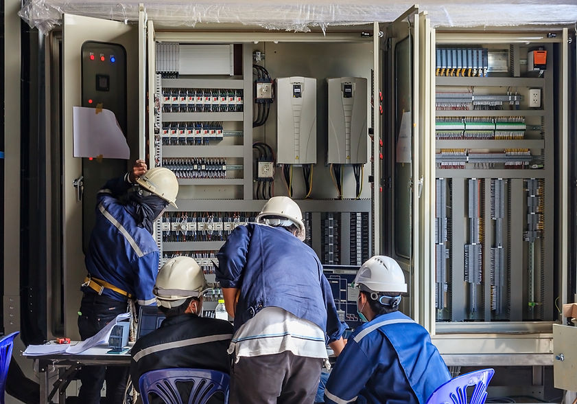 Technicians working on an Electrical Panel and doing the Commissioning and Installation.