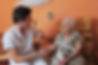 young male nurse and smiling senior woman in his bedroom