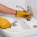 A plumber installs a new faucet for a sink