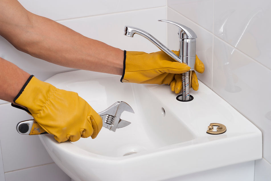 plumber installs a new tap for a sink