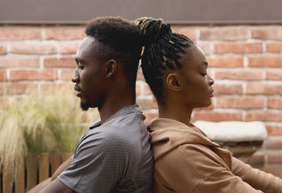 Man + woman meditating back to back
