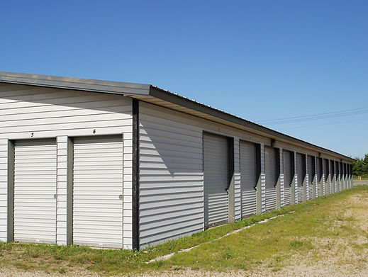 External shot of a row of grey industrial storage units with closed roller shutter doors