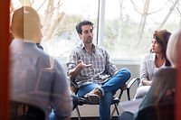 A person wearing virtual reality glasses sits on a chair