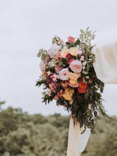 Colorful floral arrangement on a draped arch