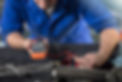 Car mechanic testing car engine in repair garage