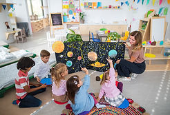 Little children in class raising their hands to answer a question