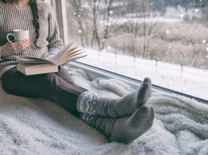 Lire avec une tasse entre les mains et un plaid