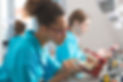 Young women wearing uniforms in a prosthodontic lab, learning prosthetic dentistry