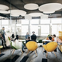 Un bureau, avec des chaises colorées, des collègues assis et debout, une réunion est en cours avec un thème principal sur la gestion du changement et l’introduction de nouvelles façons de travailler ensemble