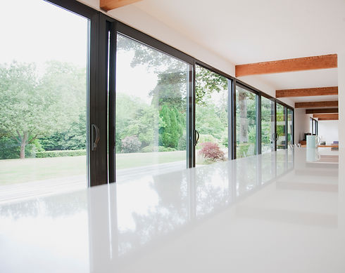 Spacious room with large glass windows overlooking a lush, green garden