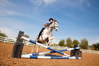 Portrait of teenage girl jumping on a horse