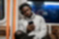 Black man using phone on the London underground
