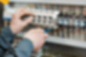 Hands of electrician with screwdriver tighten up switching electric actuator equipment in