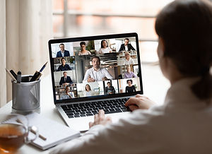 A person looking at a screen resembling a workplace meeting on Zoom