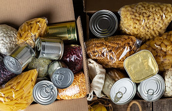 cans of food and bags of dry pasta in cardboard boxes