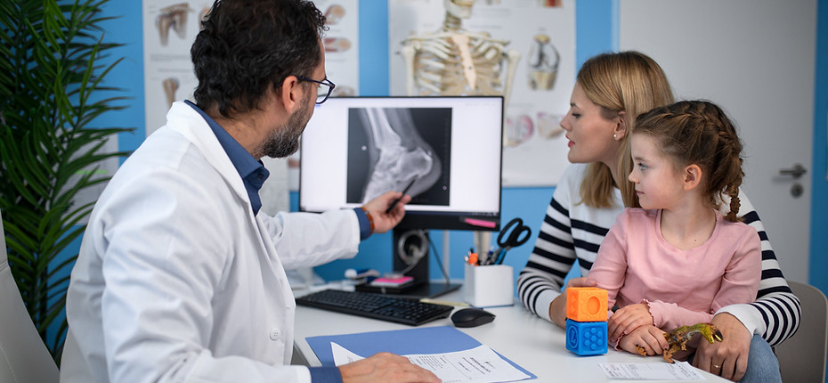 Doctor explaining x-ray to mother with child.
