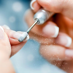 Manicurist using electric file for nail prep