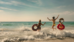women splashing in the ocean