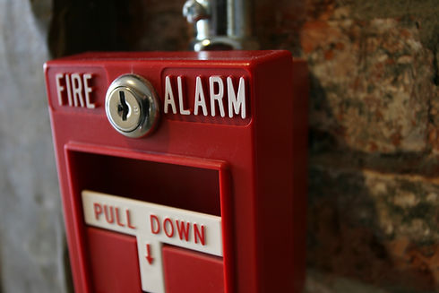 Close-up of a vintage red fire alarm pull station with a keyhole