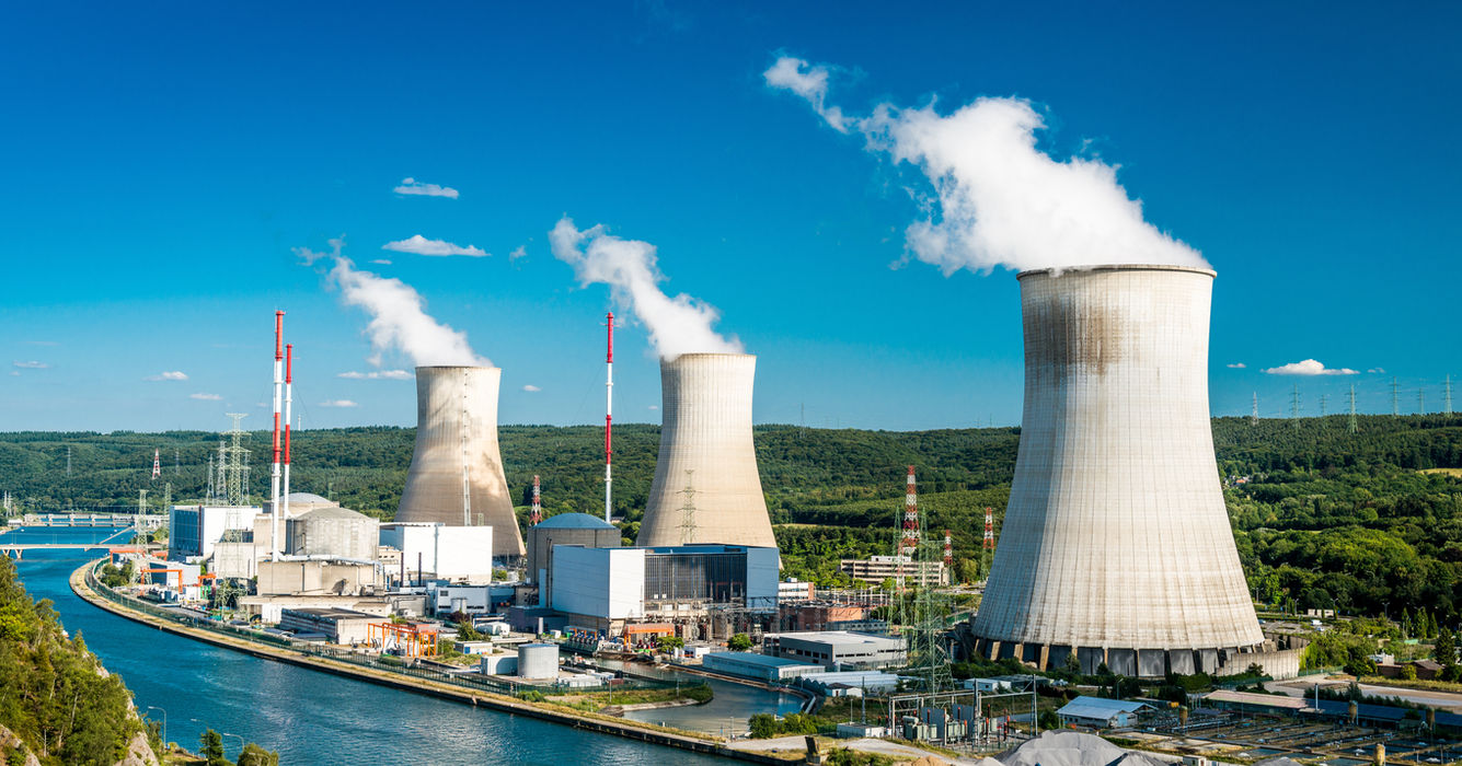 Nuclear power station with cooling towers emitting steam.