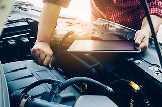 Man checking on a car engine and hold tablet