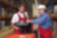 A senior worker teaching his junior the operation of a fork lift vehicle in a factory