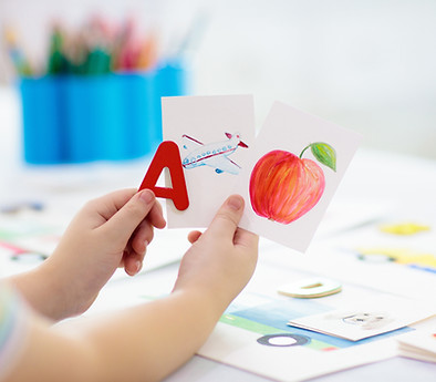A child's arms and hands holding an apple,
