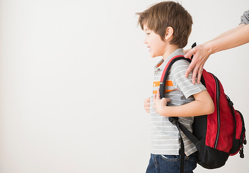 A boy with a school bag on his shoulders