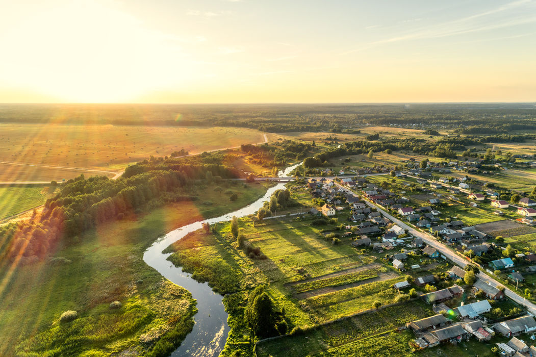 High altitude wide angle aerial drone survey showing land development site proximity to regional rivers roads and surrounding infrastructure.