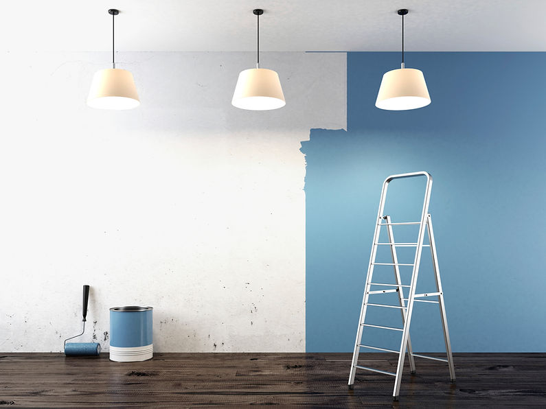 Partially painted wall with blue colour, ladder on the right
