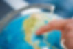 Person pointing at a globe
