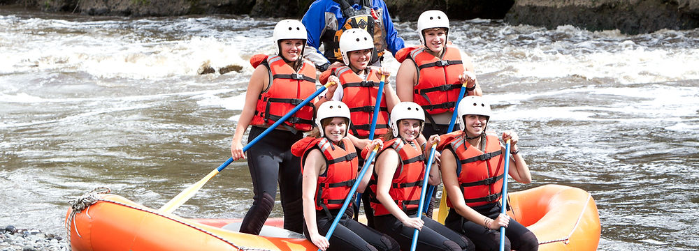 Un groupe de passionnés de rafting se fraye un chemin à travers les rapides de la rivière Doubs, offrant une vue spectaculaire sur les paysages jurassiens.
