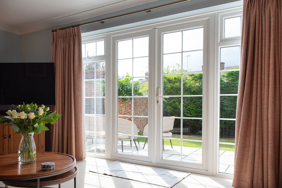 Interior view of white upvc plastic patio doors looking out from a lounge into the garden