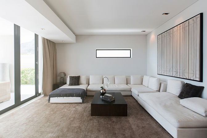Luxurious, contemporary living room with a long white sectional sofa and large windows